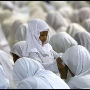 Indonesian Muslim girl adjusts mother's head scarf during mass prayer at Istiqlal Mosque in Jakarta